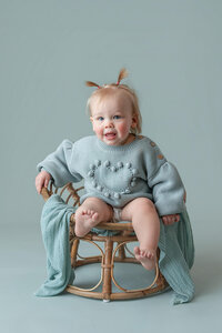 One year old little girl in a blue sweater during her milestone session at Jennifer Brandes Photography in South Central Minnesota.