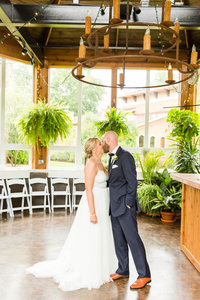 Bride and groom kissing at the Conservatory at Gervasi Vineyard photographed by akron ohio wedding photographer