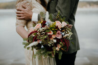 bouquet of green and pink flowers with two people in back
