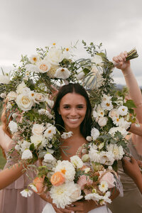 Bouquets by Flowergirl Cville framing the bride at Renback Barn. Photo by Brittany Stark Studios.