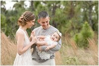 Family of three photographed candidly in a field in Miami during their family photo session with Ivanna Vidal Photography