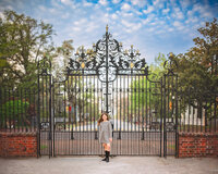 Child in a leopard print dress standing at an ornate iron gate in historic New Bern