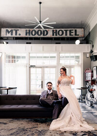 Wedding at the Hood River Hotel where bride and groom are taking a classic photo in front of the Mt. Hood Hotel sign.