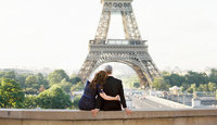 Husband and wife embrace in front of Eiffel Tower