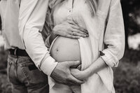 a husband cradles his wives bump during their maternity session
