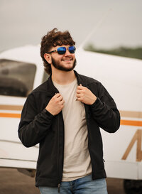 Senior portrait at a small hangar near Mobile International Airport in Mobile, Alabama — posing near airplane