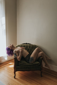 Beautifully posed model on chair in vintage styled Vancouver boudoir studio