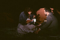 Bride and groom reading together by candlelight during their Sedona elopement