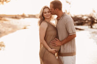 Folly Beach Maternity Photographer -- Pregnant woman poses for Maternity Photos at the Lighthouse Inlet Heritage Preserve on Folly Beach with iconic views of the Morris Island Lighthouse in the distance.