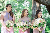 Bridesmaids reacting during wedding vows at a Los Angeles garden ceremony, captured in a candid documentary style with true to life color and emotional expressions.