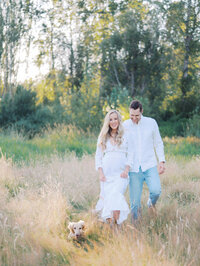 Pregnant woman and her husband walking casually in a grassy field