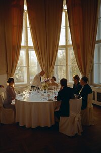 Elegant wedding reception and lunch setup at the historic Letenský zámeček in Prague, featuring a bright and airy film aesthetic.