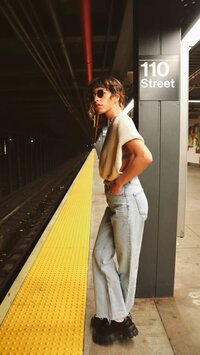 Woman in flared jeans waiting to catch the subway