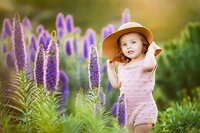 Young girl posing with her hat in a flower field in San Diego