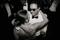 An editorial black and white capture of a couple dancing at their reception, showcasing a genuine connection and the natural unfolding of the night.