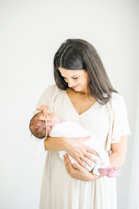 Mom cradling newborn in studio
