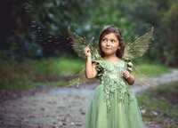 Jacksonville, FL portrait session capturing Young girl dressed as a woodland fairy with shimmering wings holds a wand as bubbles float around her during a fairy adventure signature session in Palatka.