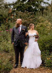 Bride and Groom standing in the garden at Mcmenamins Edgefield in Troutdale, Oregon. The Bride and Groom are posing and looking in opposite directions.