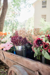 Orange and red flowers sit in a carriage