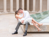 Couple posing for a romantic spring engagement portrait in front of an old building during a photo session.