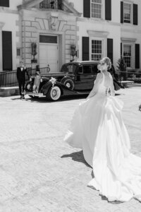 black and white image of bride walking to classic car at war memorial in grosse pointe