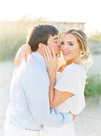 Engaged couple kissing on the beach on Tybee Island during their engagement session.