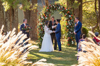 A couple holding hands as they say their vows at their wedding