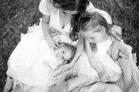 Family sitting on a blanket in an open field during a lifestyle session with Natalie Stephenson photography in Bend Oregon