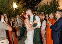 Bride and groom kissing during their exit walk with bubble in the veiled garden at the Abernethy center.