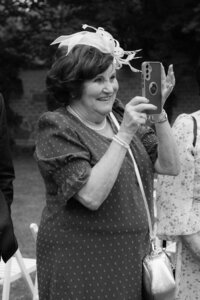 Emotional moment of a grandmother capturing memories on her camera, showing the love and joy of wedding guests.
