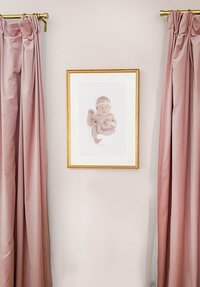 gold framed photo of newborn little girl in pink nursery