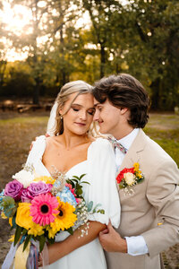 a groom leans into his bride during their couples portraits