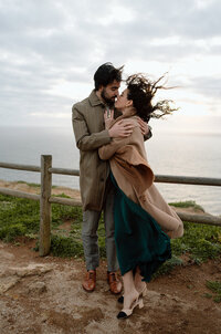 Couple hugging each other during a windy couples session in Portugal