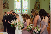 Bride and groom with their wedding party during a spiritual ceremony moment in a Los Angeles church, captured in a candid documentary style.