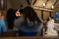 Catholic priest prepping bride and groom for holy sacrament