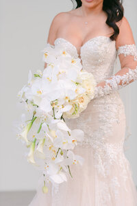 Bride holding white orchid bridal bouquet