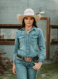 Senior portrait at Triple T Farms in Fruitdale, Alabama — walking toward the camera in a denim
outfit and cowboy hat.