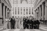 Large wedding party posing in front of the historic Chicago Board of Trade Building