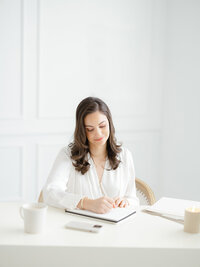 A photo of a Dallas Texas business woman at her desk looking down working on a project.