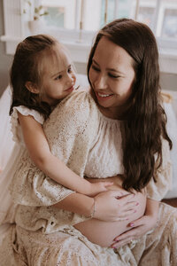 Smiling mom and daughter at Maison Charlottesville during Amy Mitchell's maternity photoshoot.