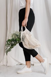 woman-in-black-pants-holding-net-bag-3738029