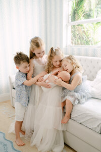 Four siblings holding their newborn baby brother during their newborn session in Miami