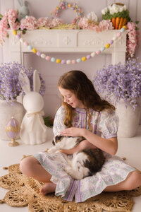 Little girl pets a live bunny during Easter Mini Session at Holy City Babies Portrait Studio in Charleston, SC.