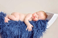 Newborn baby boy wrapped in navy knit photographed in New Bern studio