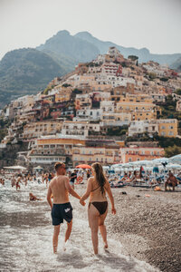 couple holding hands in positano