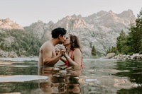man and woman kissing in water