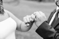 Couple pinky promises each other with wedding bands in Knoxville