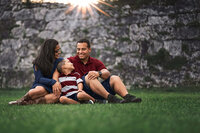 Family standing together along stone wall and path during outdoor portrait session in Fort Macon North Carolina