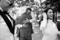 Groom hugging a guest during a joyful wedding moment captured in Huntsville, Alabama.