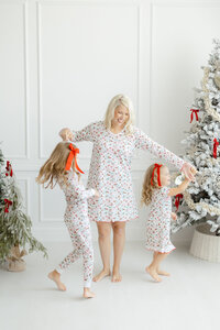 A mother dancing with her children as they are dressed in Dondolo christmas clothes.